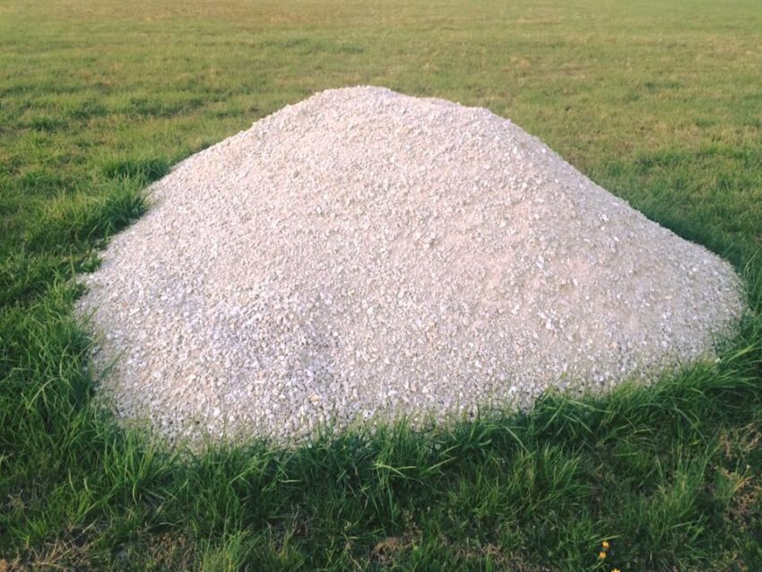 A pile of white gravel on grass. https://www.facebook.com/gravelpileandfriends