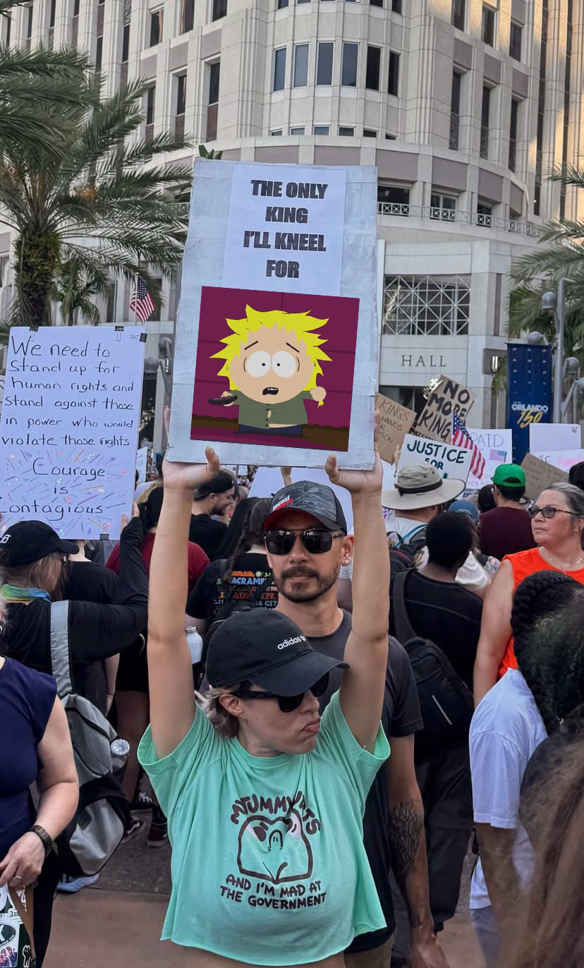A picture of a girl holding up a sign at a rally for No Kings. However, the sign reads "HE ONLY KING I'LL KNEE FOR" and there's a picture of Tweek Tweak from South Park pasted into the image on her poster sign.