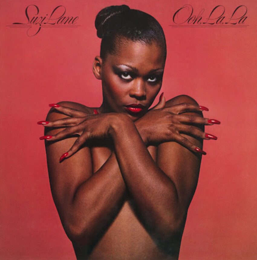Cover art of Suzi Lane's 1979 EP "Ooh, La, La". She's on the cover, nude, her arms over her breasts hiding them. She's wearing bright red long fingernails.